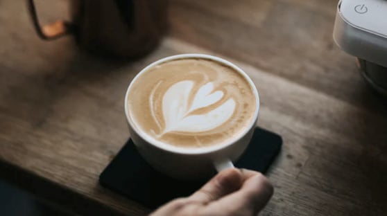 a cup of cappuccino on a wooden counter