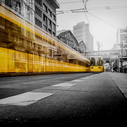 there is a photo of a city street, where trams pass by on rails